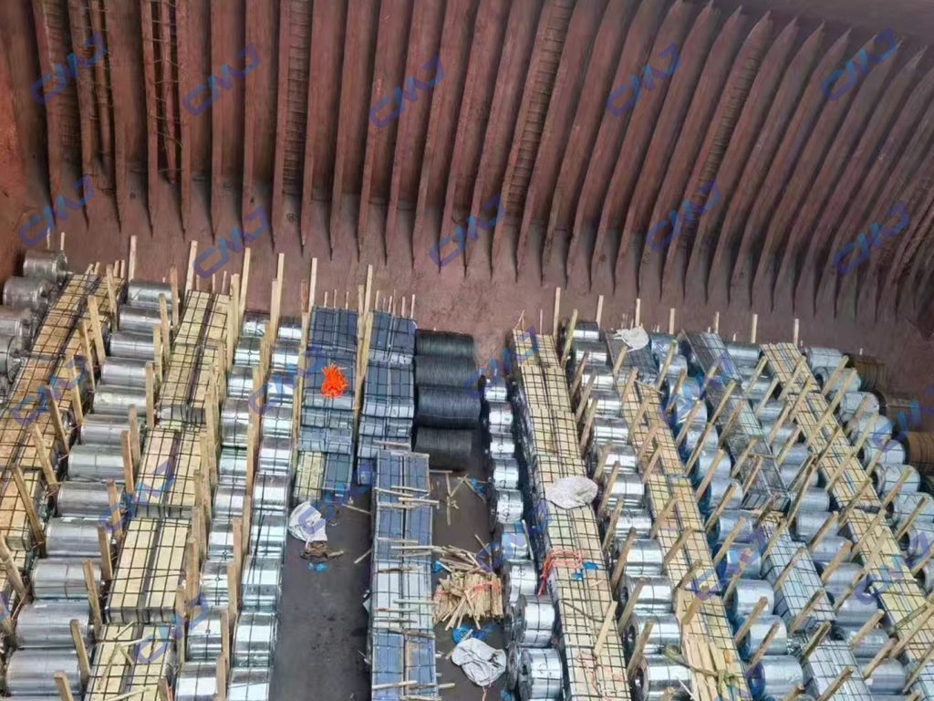 Carbon steel coils and wire bundles secured with wooden bracing inside ship hold