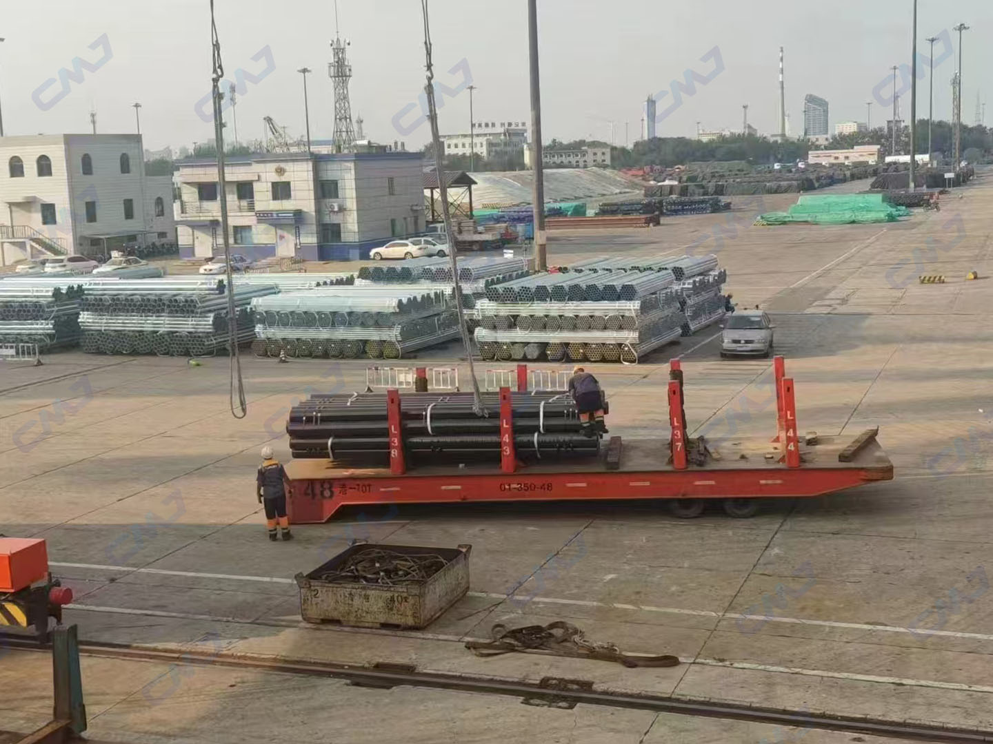 Black carbon steel pipes being loaded onto flatbed trailer at Tianjin Port for exportundefined